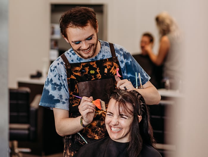 Stylist coloring client's hair